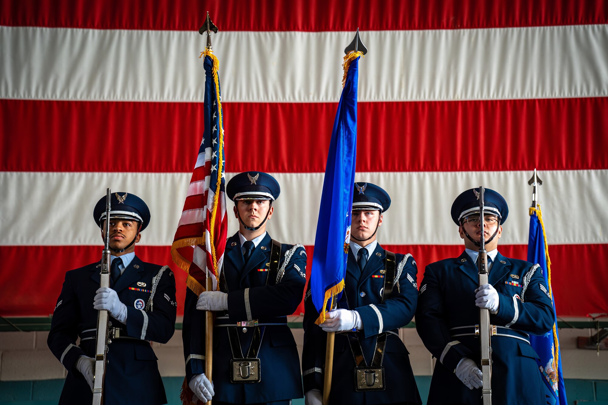 Airmen hold flags.
