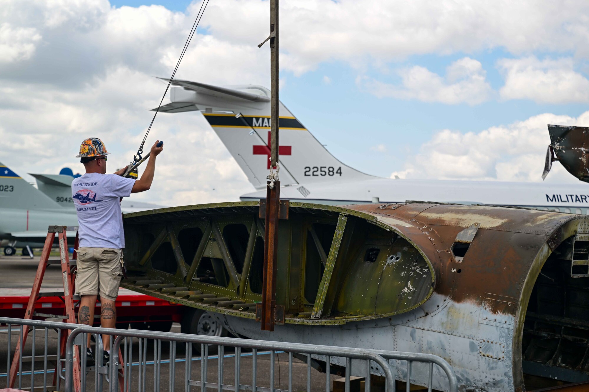 Jay Penry, Worldwide Aircraft recovery lead, adjusts a strap to make repairs to a C-46 Commando at the Air Mobility Command Museum on Dover Air Force Base, Delaware, June 5, 2023. The C-46 was utilized for transporting personnel and cargo such as ammunition, fuel, light artillery and aircraft parts in the China-Burma-India theater during World War II. (U.S. Air Force photo by Staff Sgt. Faith Barron)