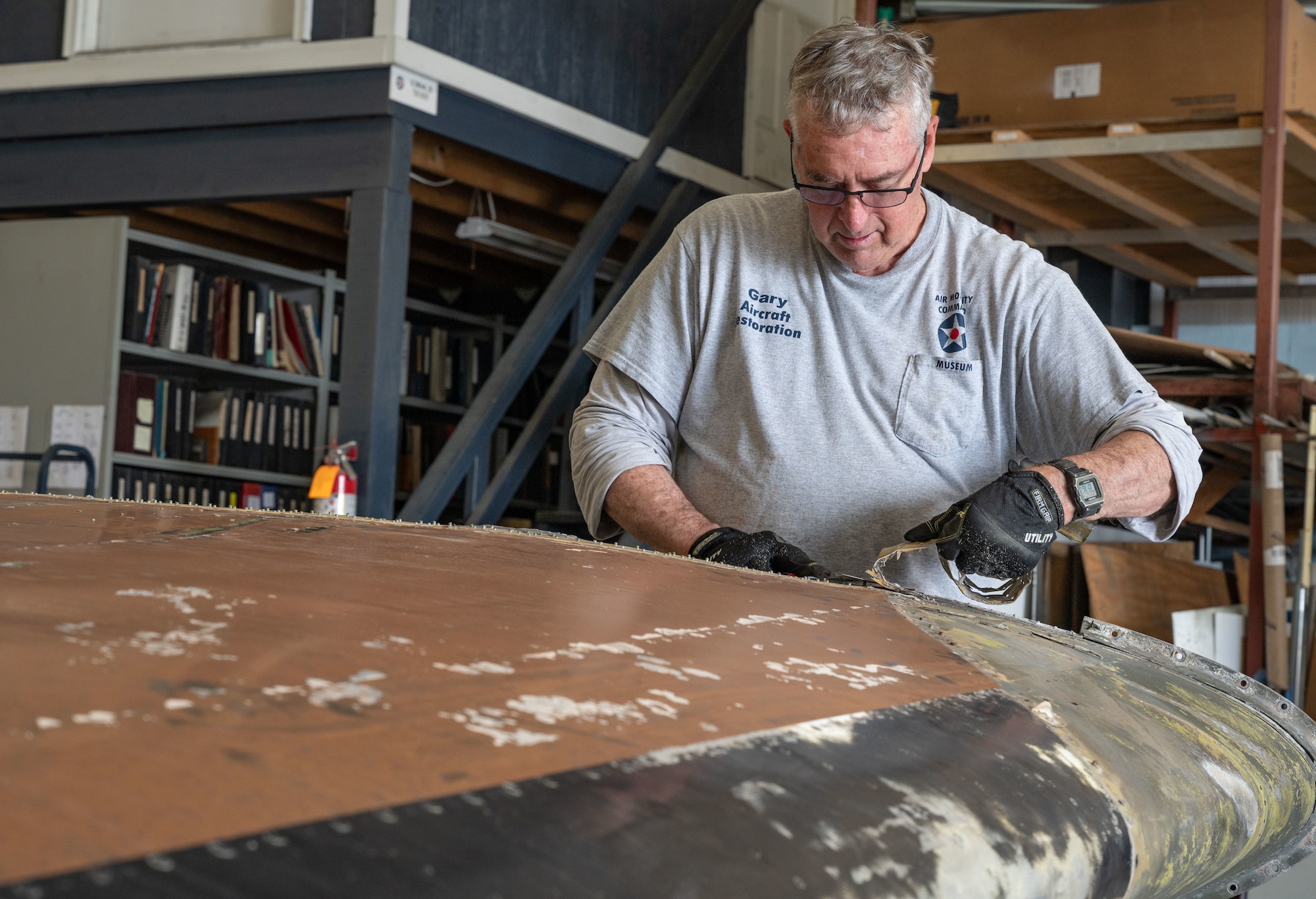 Gary Kutsch, Air Mobility Command Museum volunteer, smooths down rivets on the wing of a C-46 Commando at the AMC Museum on Dover Air Force Base, Delaware, June 12, 2023. The C-46 is currently undergoing the restoration process at the AMC Museum, which is expected to take up to two years. (U.S. Air Force photo by Airman 1st Class Dieondiere Jefferies)