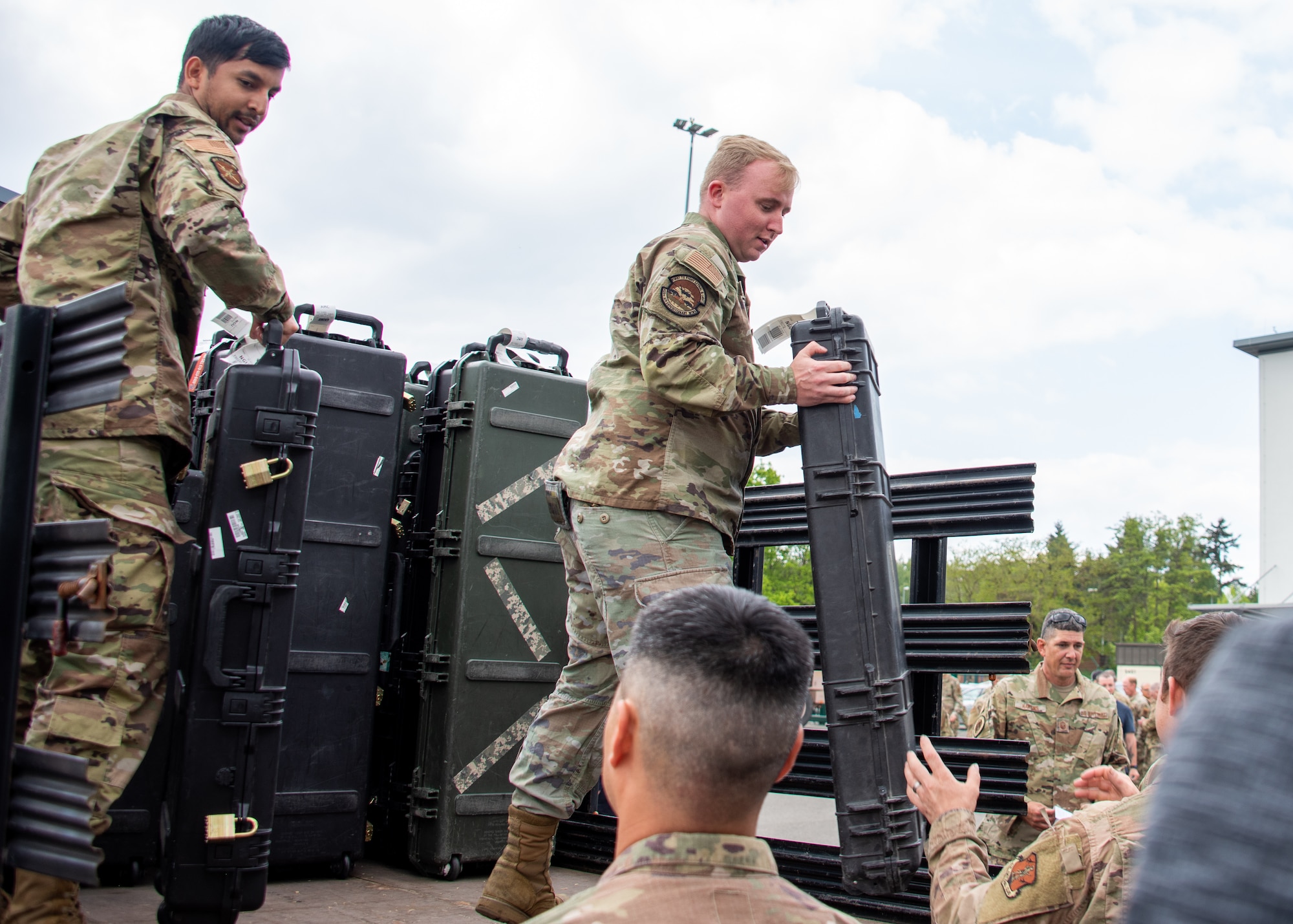 U.S. Air Force Airmen distribute weapons cases to troops for in-processing at Ramstein Air Base Germany, May 18, 2023.