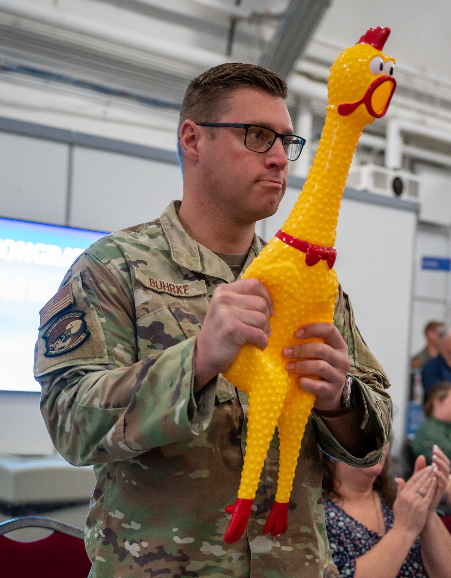 Capt. Matthew Buhrke, 436th Operations Support Squadron assistant operations officer, squeezes “Cluck Norris,” 436th OSS mascot, during a change of command ceremony at Dover Air Force Base, Delaware, June 14, 2023. The ceremony saw Lt. Col. Steven Hawkins relinquish command to Gerlach. The 436th OSS provides dependable air traffic control, airfield management, weather, intelligence, life support, tactics, mission planning and aircrew training services to support Team Dover’s airlift mission. (U.S. Air Force photo by Airman 1st Class Amanda Jett)