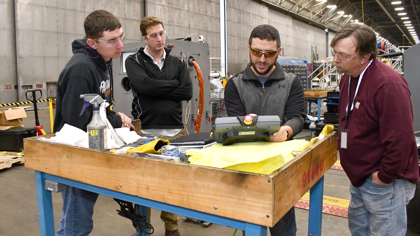 From left, Skylar Fornes, metal spray artisan; James Bilderback, materials lab engineer; Clint Fees, VRC Systems trainer; and Chuck Overly, metal spray artisan, take part in training for a new mobile, autonomous cold spray metallization system that is being fielded on H-1 line at the Fleet Readiness Center East (FRCE) detachment on board Marine Corps Air Station New River. Officials say the new system will aid FRCE in reducing aircraft maintenance turnaround times and decreasing costs.