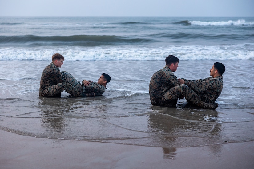 Marine perform crunches on the beach.