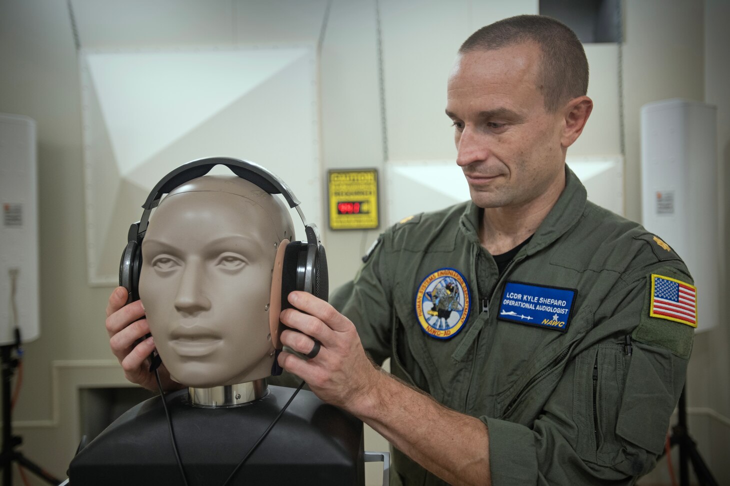 Lt. Cmdr. Kyle Shepard, resident audiologist and researcher at the Naval Air Warfare Center Aircraft Division, demonstrates audio testing in an anechoic chamber at NAS Patuxent River,
Maryland.