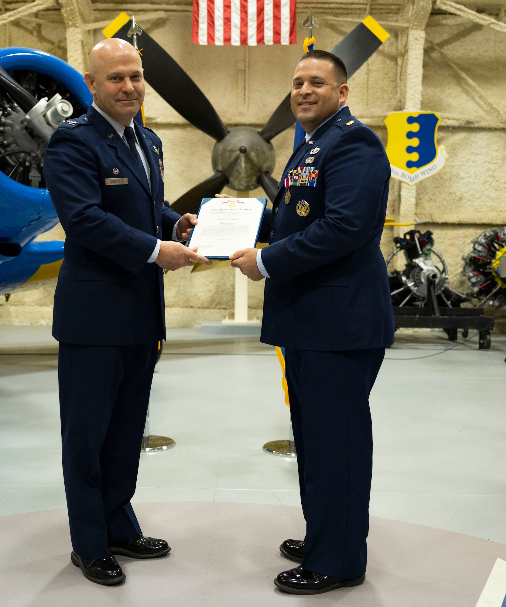 U.S. Air Force Col Joseph Sheffield (left), 28th Bomb Wing commander, awards Maj Nicholas DeFranco, outgoing 28th Comptroller Squadron commander, the Meritorious Service Medal at Ellsworth Air Force Base, South Dakota, June 6, 2023.