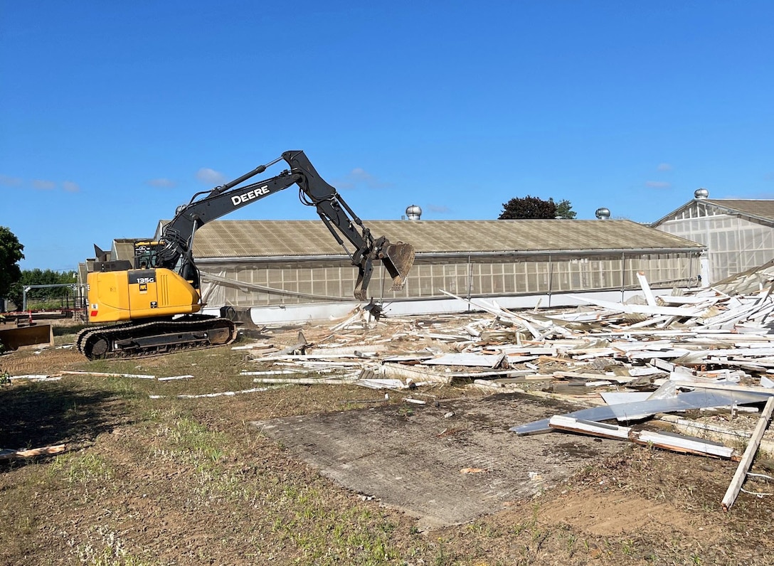 Excavator demolishes an old screenhouse.