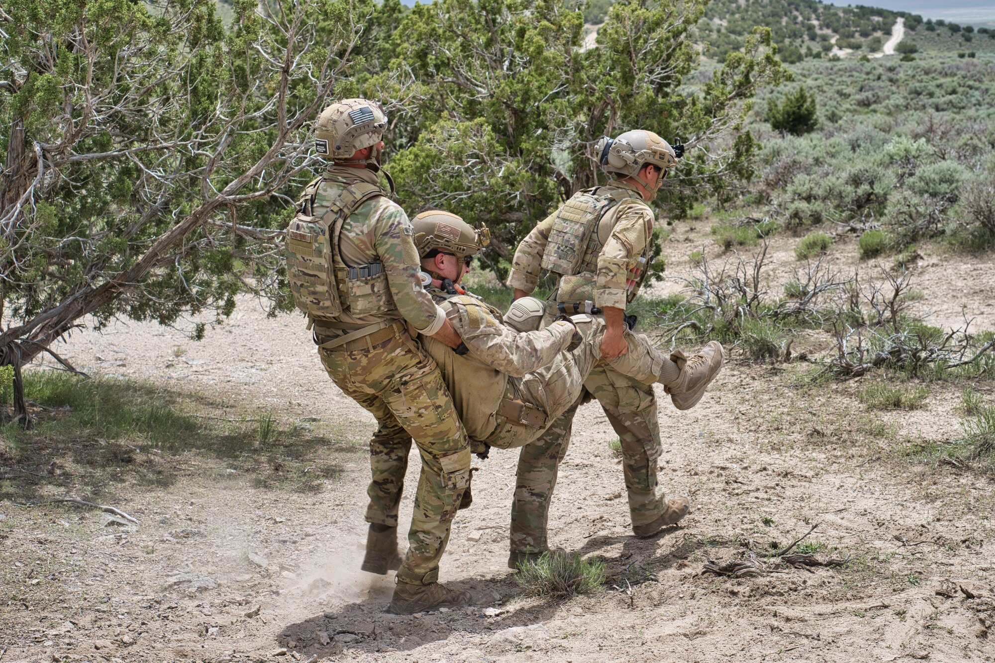 Two airman performing a chair carry on another airman