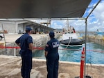U.S. Coast Guard Incident Management Assist Team members observe efforts to refloat the tug Polaris on June 11, 2023, in the Port of Guam.