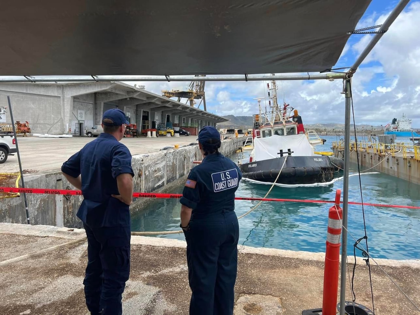 U.S. Coast Guard Incident Management Assist Team members observe efforts to refloat the tug Polaris on June 11, 2023, in the Port of Guam.