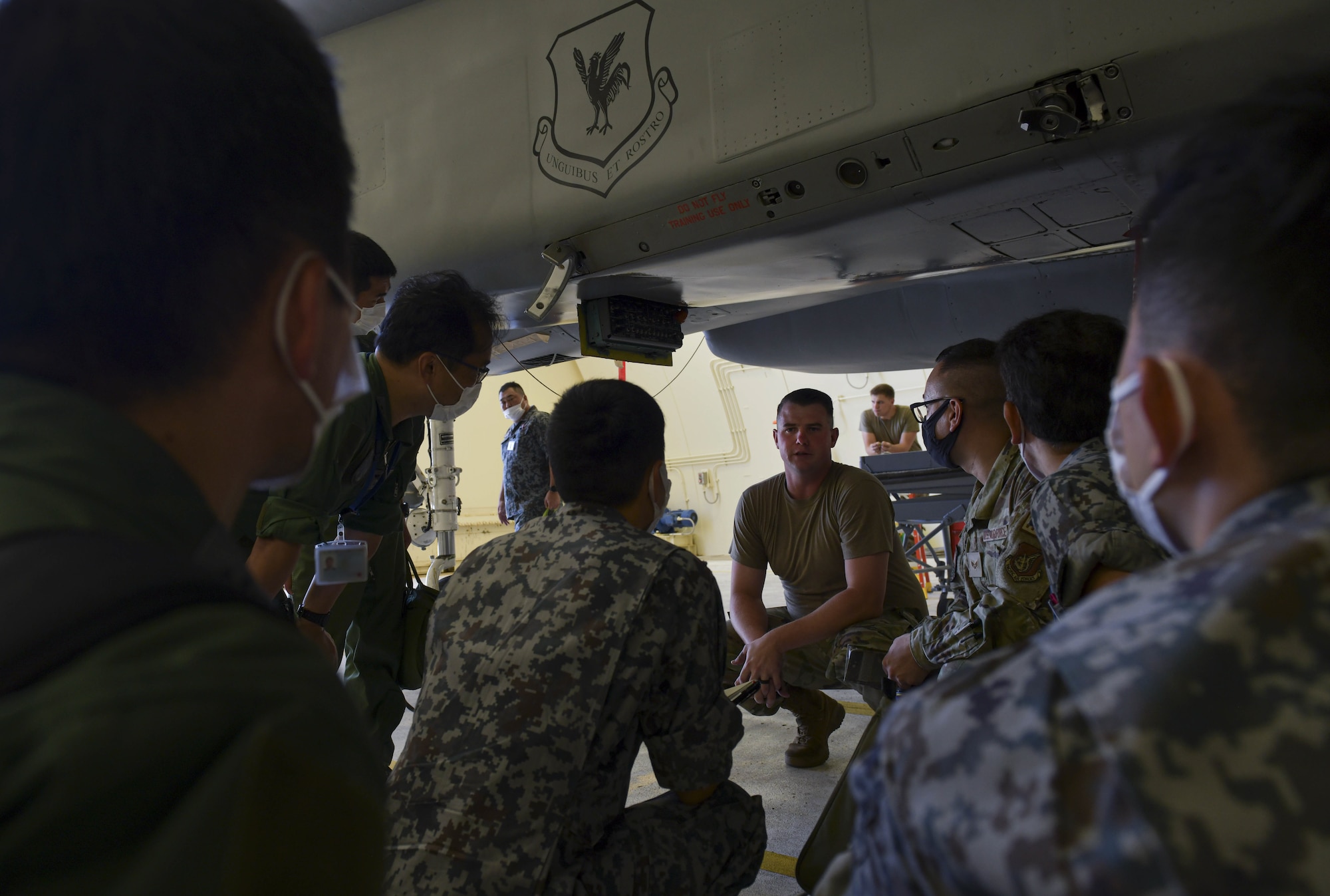 U.S. Air Force Staff Sgt. Zachary Nelson, center, 18th Aircraft Maintenance Squadron F-15 Eagle crew chief instructor, briefs Japan Self-Defense Forces members on hot pit refueling duty responsibilities during a Bilateral Defense of Okinawa Working Group at Kadena Air Base, Japan, Aug. 2, 2022. The BDOWG is an annual event where Japanese and US Forces assigned to Okinawa come together to discuss ways to further bilateral training, operational integration and overall defense, safety, and partnership in the region. (U.S. Air Force photo by Staff Sgt. Savannah L. Waters)