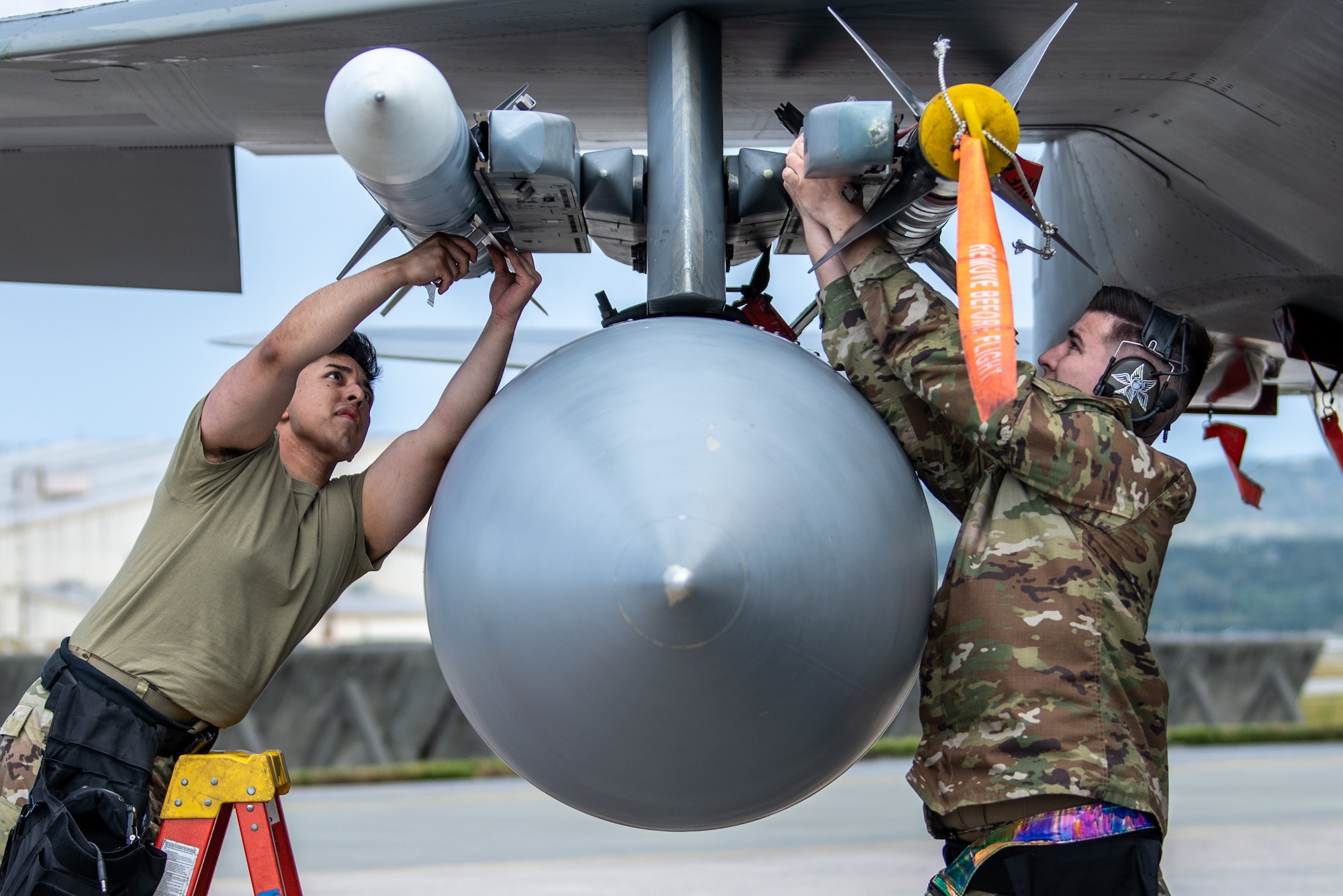 Senior Airman Kevin Arredondo, left, 44th Aircraft Maintenance Unit weapons load crew member, and Staff Sgt. Bryor Mortiz, right, 44th AMU weapons crew chief, load ordnance onto an F-15C Eagle assigned to the 44th Fighter Squadron during Shogun Showdown, a weapons load competition at Kadena Air Base, Japan, Feb. 3, 2023. The purpose of the event was to hold friendly competition amongst weapons load crews for several different airframes, showcase multi-capable Airmen in action and demonstrate the work that goes into generating a combat-ready aircraft. (U.S. Air Force photo by Airman 1st Class Sebastian Romawac)