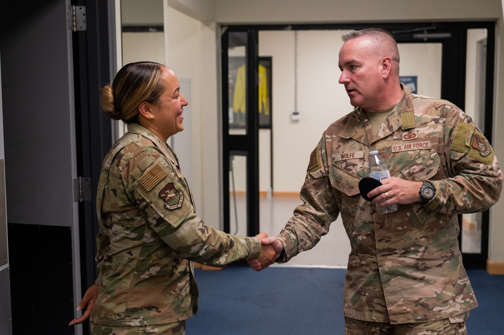 Chief Master Sgt. David Wolfe presents a coin to Tech. Sgt. Emeliana Punahele-Yau during his visit to Kunsan Air Base