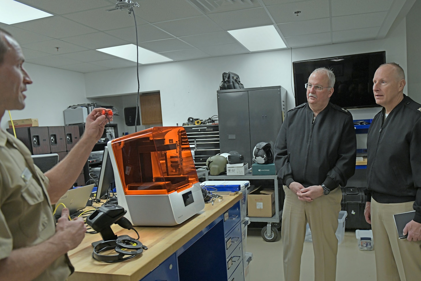 Lt. Cmdr. Kyle Shepard, resident audiologist and researcher at the Naval Air Warfare Center Aircraft Division, describes a simple process for the Navy to print custom ear plugs for its sailors using a digital ear scanner and 3D printer to Navy Surgeon General Rear Adm. Bruce Gillingham at Naval Air Station Patuxent River, Maryland.