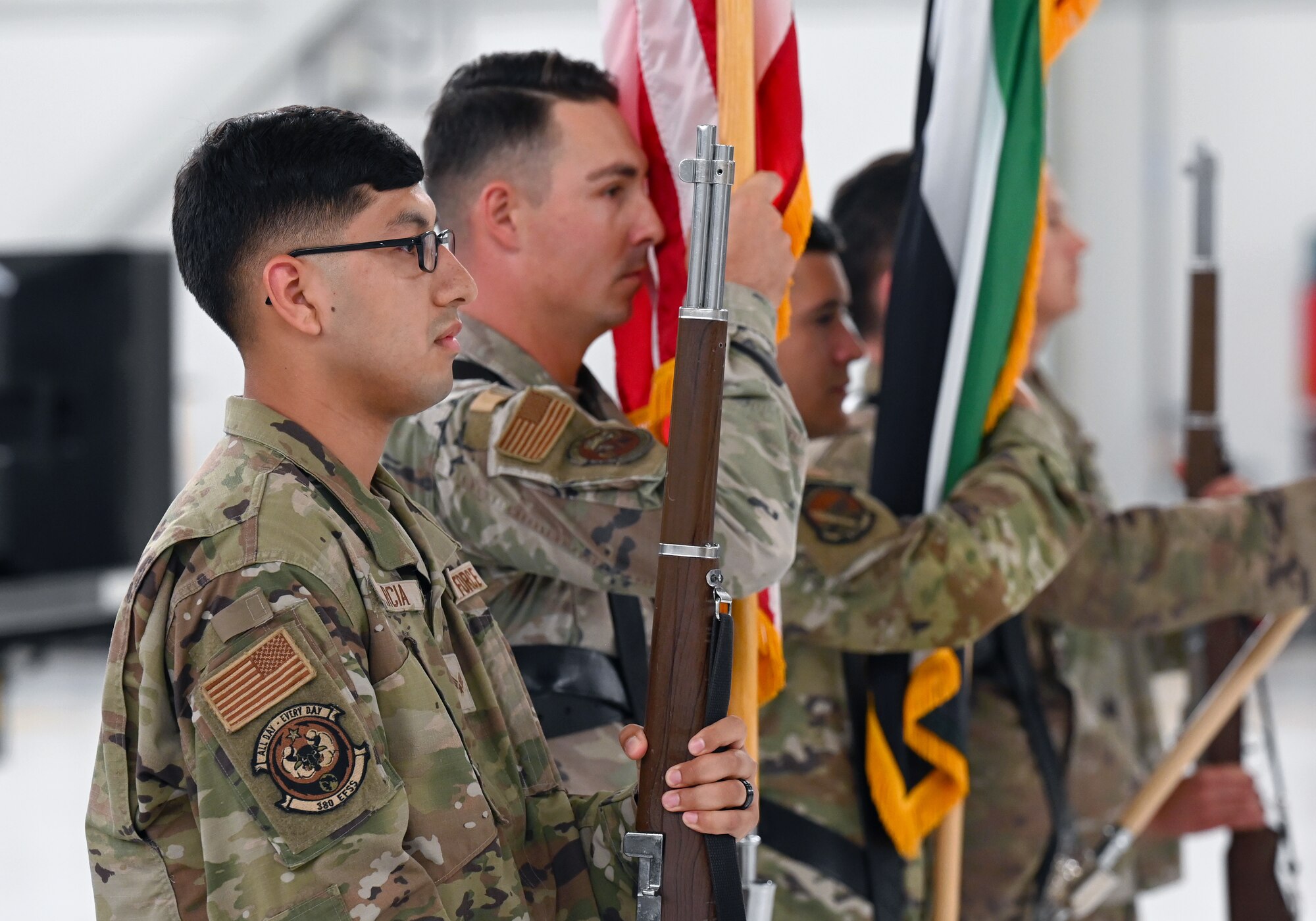 A photo of the honor guard holding flags and rifles.