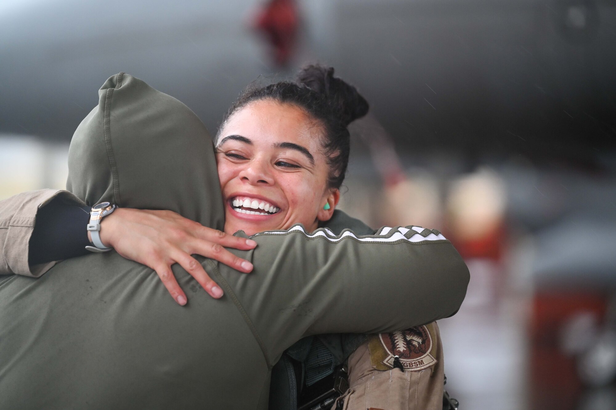 A pilot hugs her friend after exiting her aircraft.