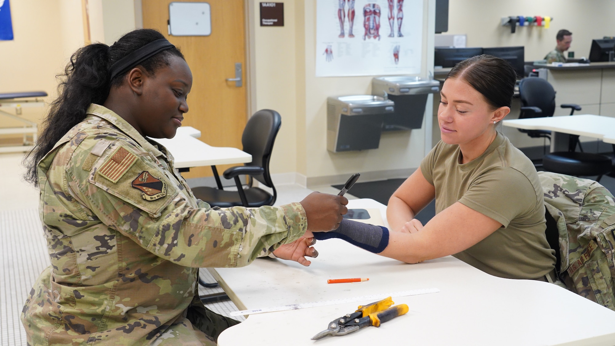 Staff Sgt. Kayla Britford (left), an 88th Operational Medical Readiness Squadron occupational therapy technician, practices an outline to make a new cast for an Airman in the Physical Therapy Clinic at Wright-Patterson Medical Center, June 13, 2023. The squadron “dominates the dirty work” by ensuring Airmen and military members are medically ready to execute their missions in home-base and deployed locations. (U.S. Air Force photo by Kenneth J. Stiles)