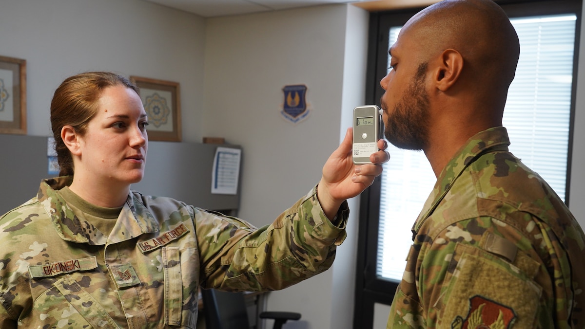 Tech. Sgt. Stephanie Okonski, an 88th Operational Medical Readiness Squadron certified alcohol and drug abuse counselor, demonstrates the use of a breathalyzer to Senior Airman McKinley Gillis III, a Mental Health Flight technician, to assist in his training as an ADAPT counselor at Wright-Patterson Medical Center on June 13, 2023. The squadron “dominates the dirty work” by ensuring Airmen and military members are medically ready to execute their missions in home-base and deployed locations. (U.S. Air Force photo by Kenneth J. Stiles)
