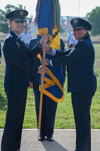 U.S. Air Force Maj. Gen. Michele Edmondson, 2nd Air Force commander, passes the guidon to Col. Angelina Maguinness, 17th TRW commander, upon assuming command during the change of command ceremony at Goodfellow Air Force Base, Texas, June 16, 2023. Maguinness will be responsible for training, transforming, and empowering more than 14,000 firefighting, intelligence, surveillance, and reconnaissance warriors annually for the United States Air Force, Army, Marine Corps, Navy, Space Force, Coast Guard and other government agencies and allied nations. (U.S. Air Force photo by Senior Airman Sarah Williams)