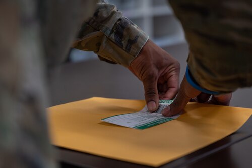 A photo of an Airman sealing an envelope.