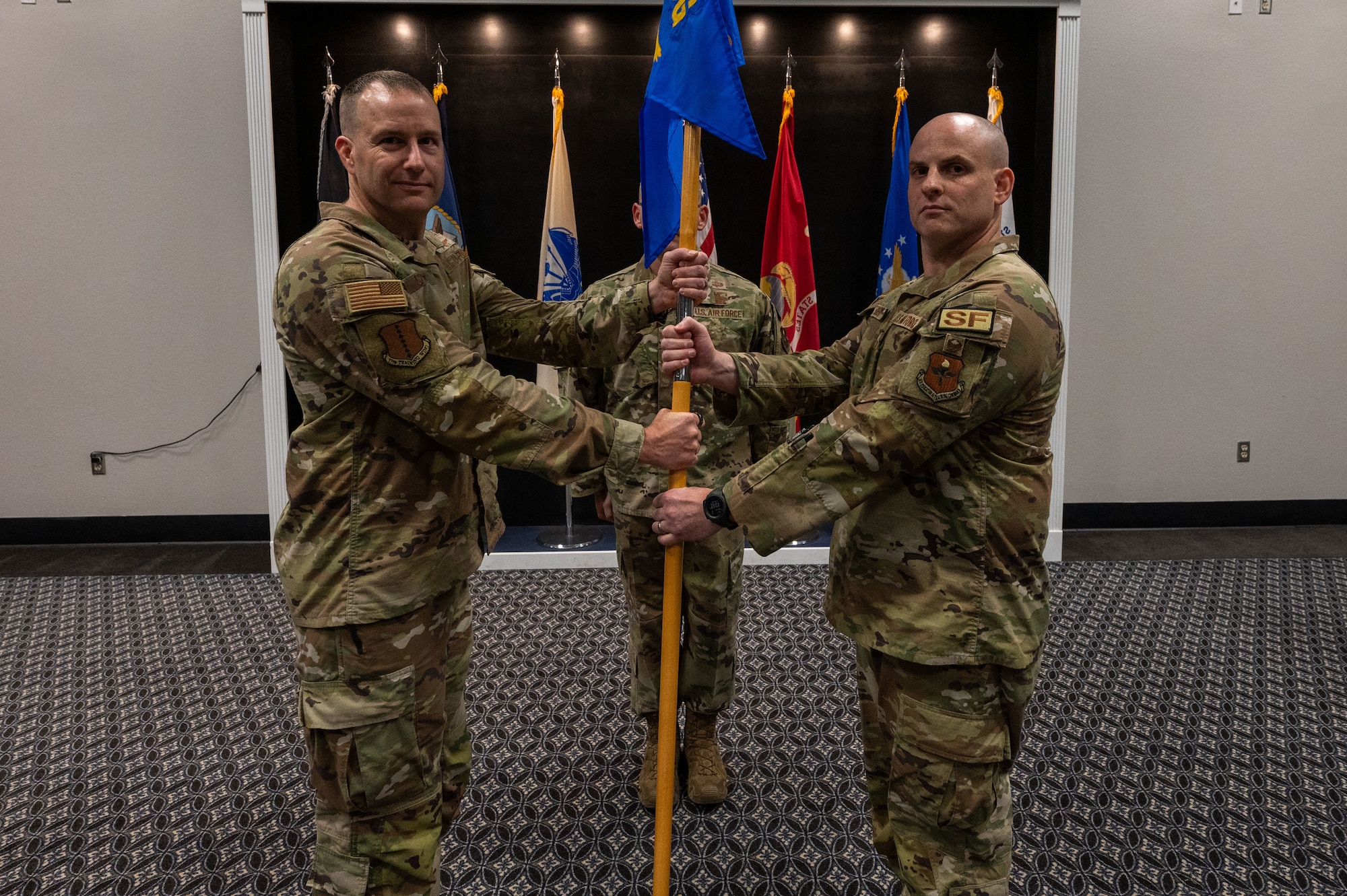 U.S. Air Force Col. Christopher Corbett, 17th Training Wing vice commander, presents Maj. Jeremy S. Berger, incoming 17th Security Forces Squadron commander, with the guidon during the change of command ceremony at the Powell Event center, Goodfellow Air Force Base, Texas, June 15, 2023. Berger served as the 55th Security Forces Squadron, director of operations at Offutt Air Force Base, Nebraska. (U.S. Air Force photo by Staff Sgt. Jermaine Ayers)