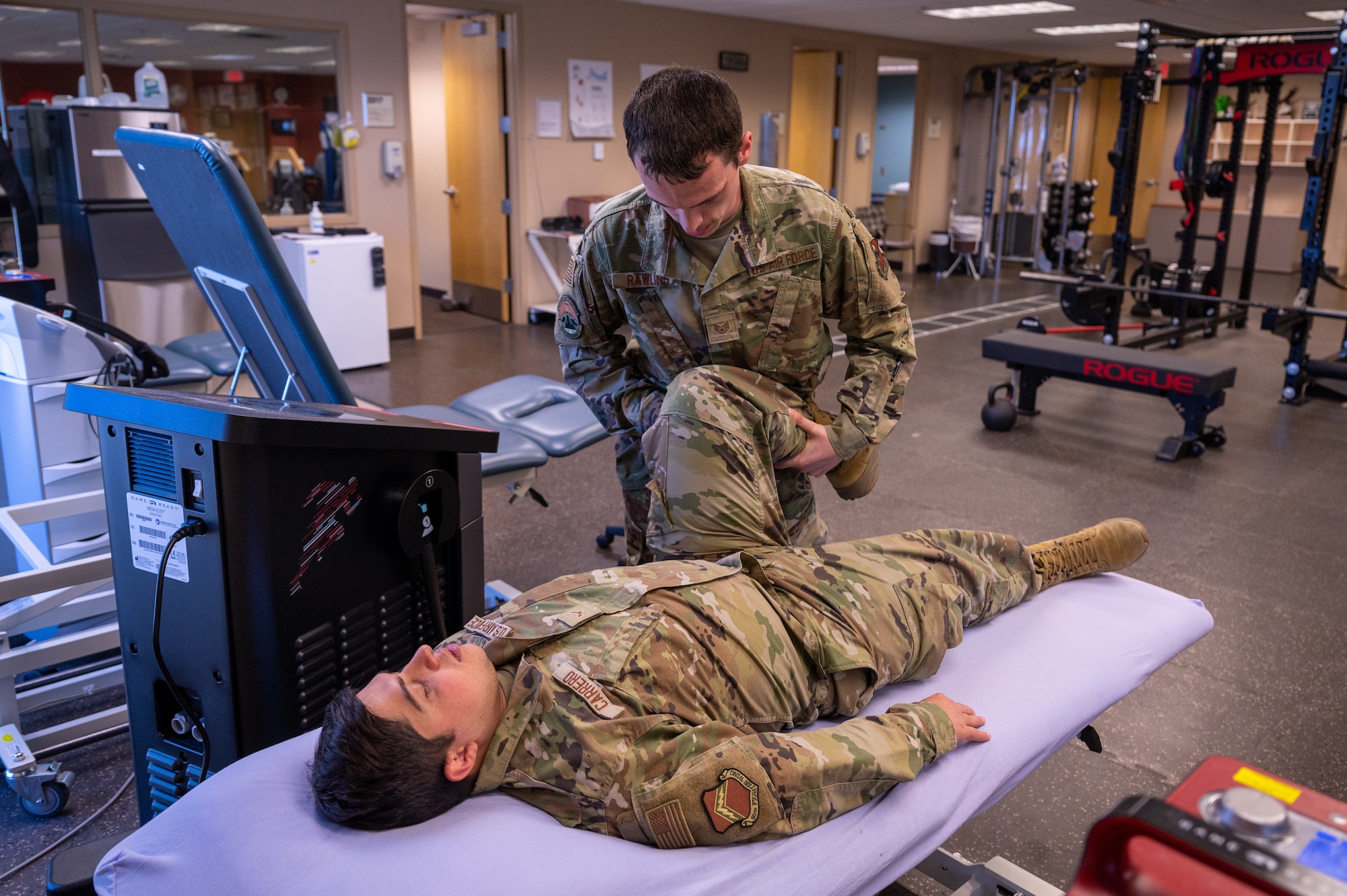 U.S. Air Force Staff Sgt. Terry Rawlins, 56th Medical Group human performance flight non-commissioned officer in charge, examines the leg flexibility of, U.S. Air Force Airman 1st Class Elias Carrero, 56th Fighter Wing public affairs specialist, June 15, 2023, at Luke Air Force Base, Arizona.