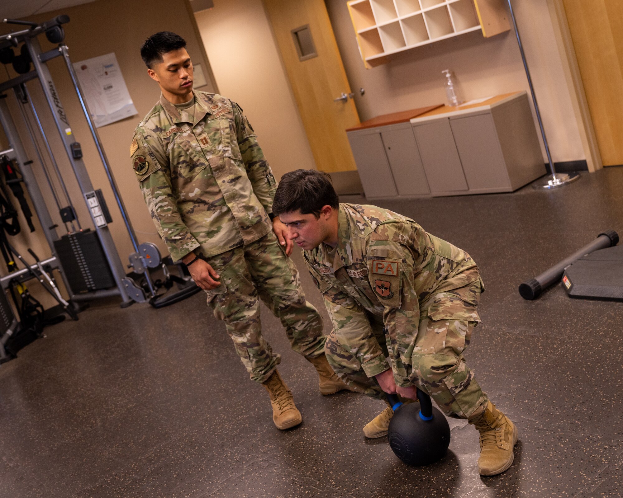 U.S. Air Force Capt. Xavier Cardinal, 56th Medical Group staff physical therapist, coaches U.S. Air Force Airman 1st Class Elias Carrero, 56th Fighter Wing public affairs specialist, on proper deadlift form, June 15, 2023, at Luke Air Force Base, Arizona.