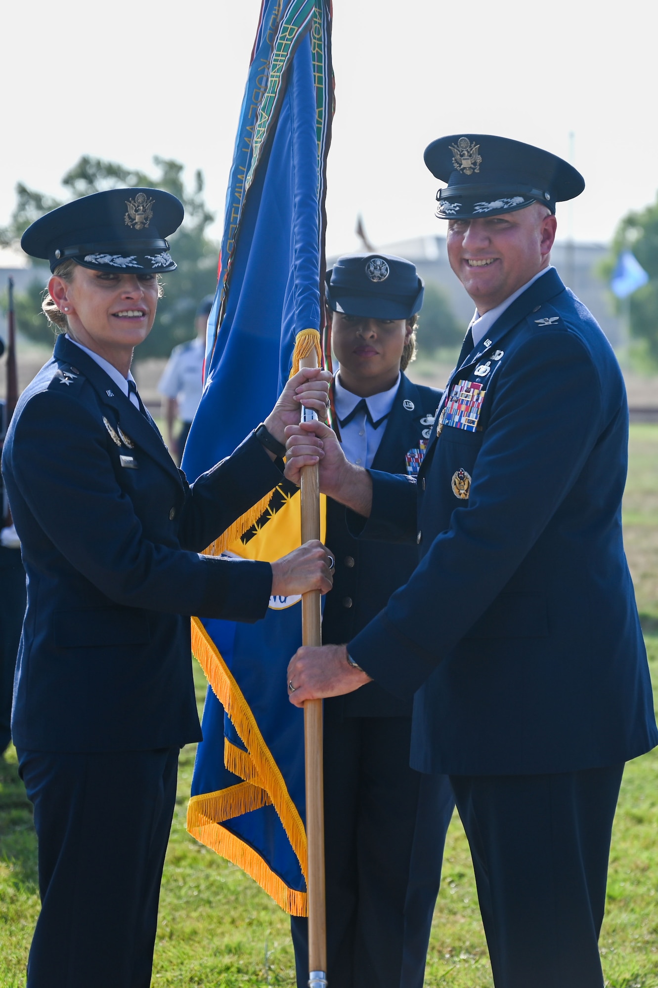 U.S. Air Force Col. Matthew Reilman, outgoing 17th Training Wing commander, passes the guidon to Maj. Gen. Michele Edmondson, 2nd Air Force commander, relinquishing command during the change of command ceremony at Goodfellow Air Force Base, Texas, June 16, 2023. Passing the guidon represents the transfer of leadership responsibilities to the next commander. (U.S. Air Force photo by Senior Airman Sarah Williams)