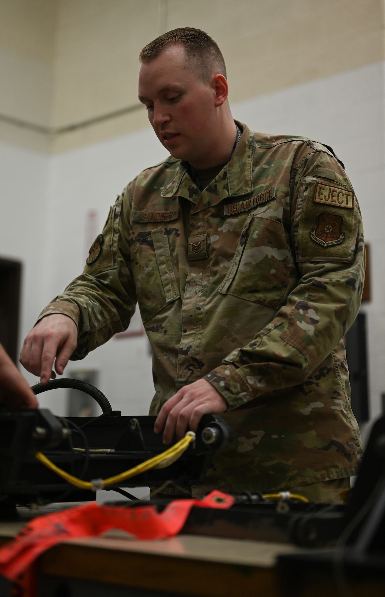 U.S. Air Force Staff Sgt. Marcus Sandifer, 509th Maintenance Squadron egress section non-commissioned officer in charge, inspects a B-2 Spirit ejection training seat at Whiteman Air Force Base, Missouri, June 15, 2023. Egress is the system that controls the seats ejecting out of the B-2, in the case of an emergency, requiring the pilot and mission commander to get out of the aircraft in a hurry. (U.S. Air Force photo by Senior Airman Victoria Hommel)