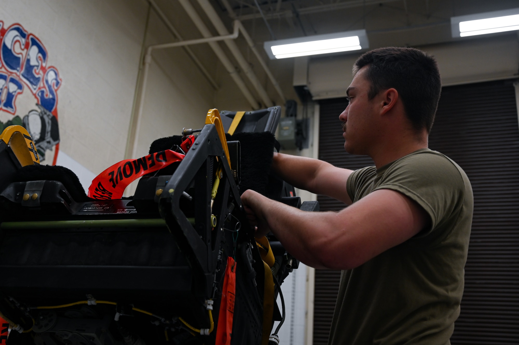 U.S. Air Force Airman 1st Class Korbyn Armijo-Pemble, 509th Maintenance Squadron aircrew egress journeyman, sets up a B-2 Spirit ejection training seat at Whiteman Air Force Base, Missouri, June 15, 2023. Egress is the system that controls the seats ejecting out of the B-2, in the case of an emergency, requiring the pilot and mission commander to get out of the aircraft in a hurry. (U.S. Air Force photo by Senior Airman Victoria Hommel)