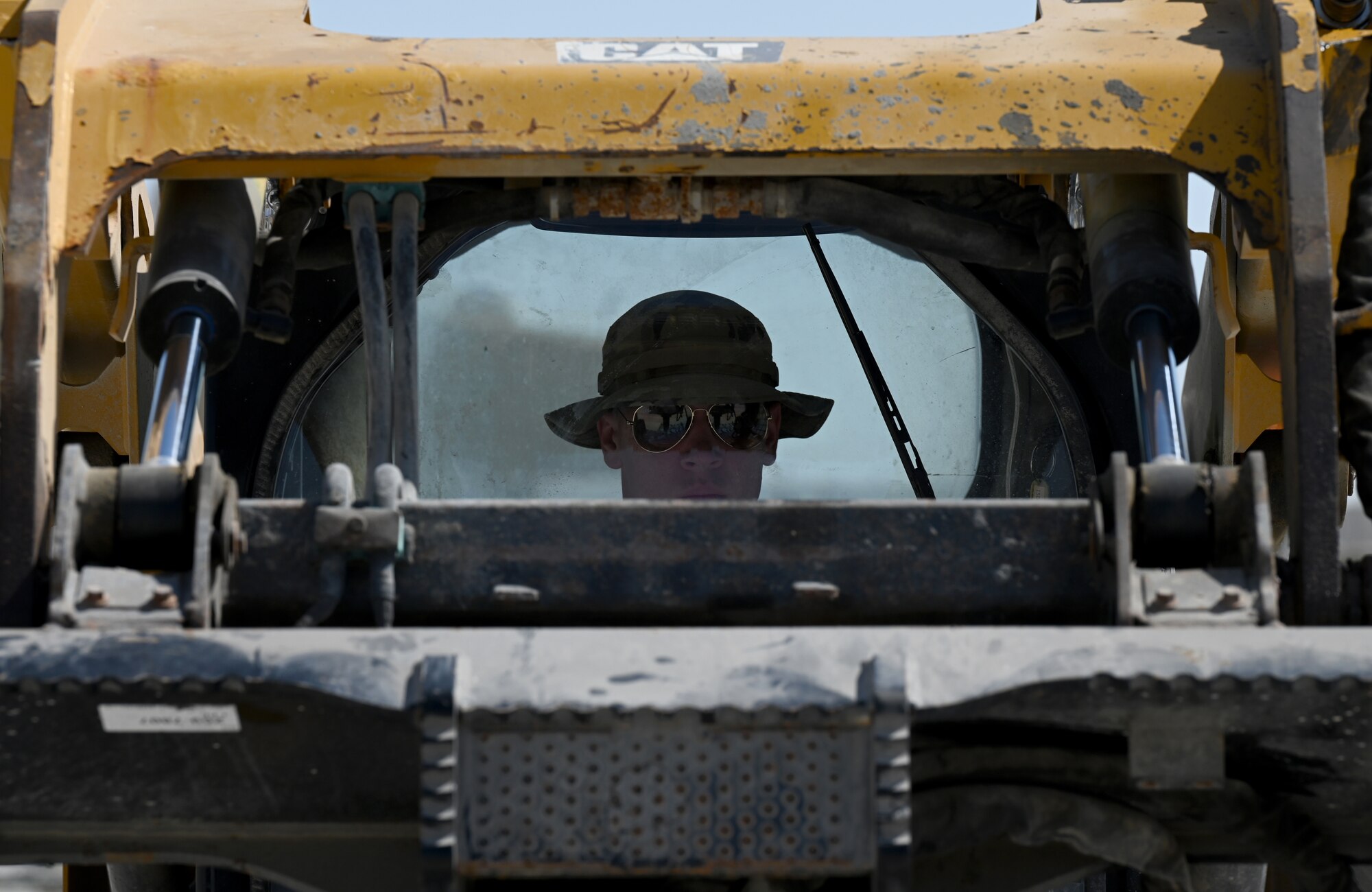 A photo of an Airmen driving a compact track loader.