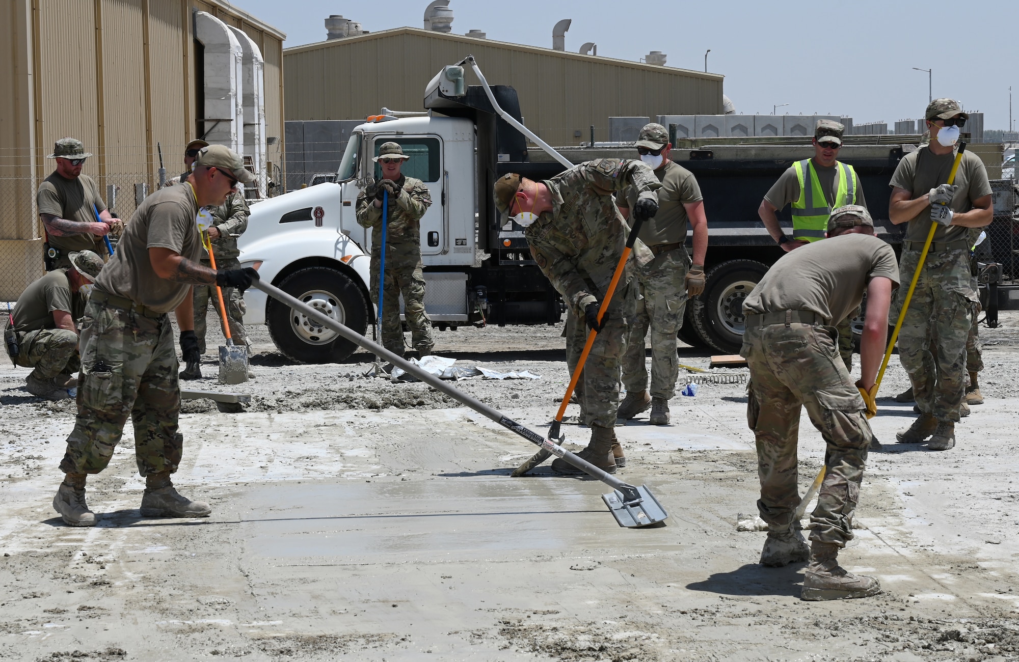 A photo of a group of Airmen smoothing out concrete.