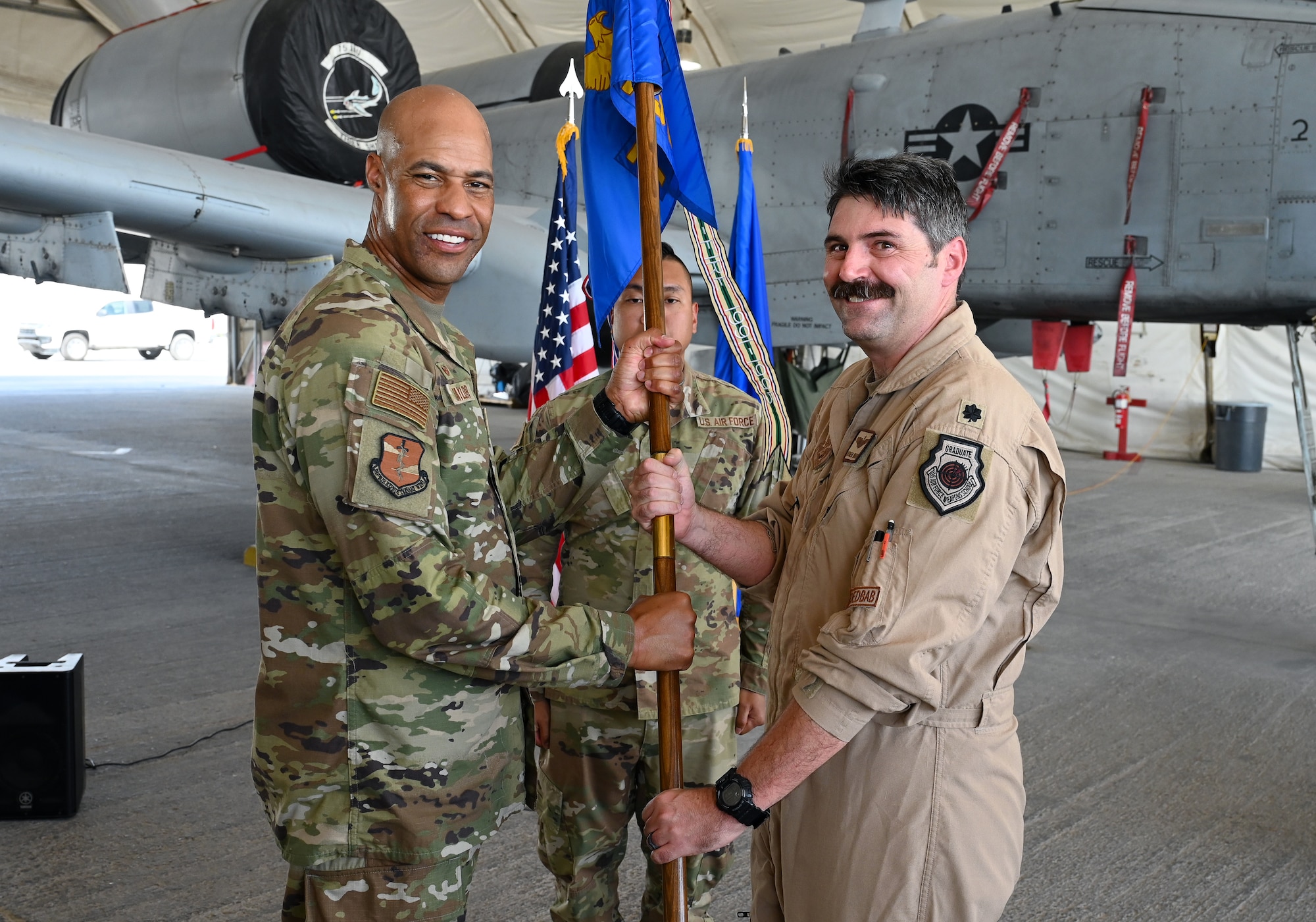 A photo of two Airmen holding a guidon.