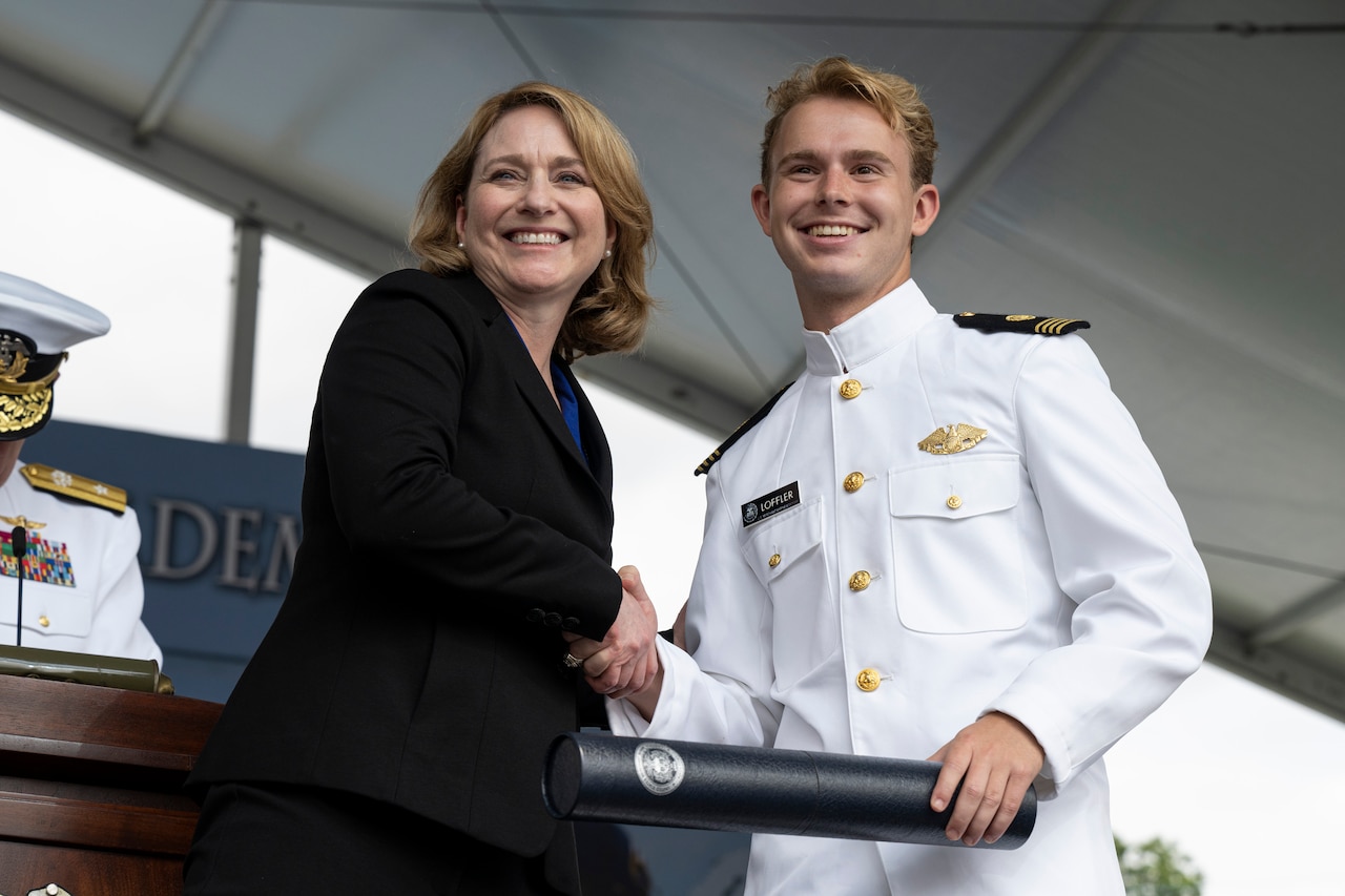 Deputy Secretary of Defense Kathleen Hicks shakes hands with a graduate student.