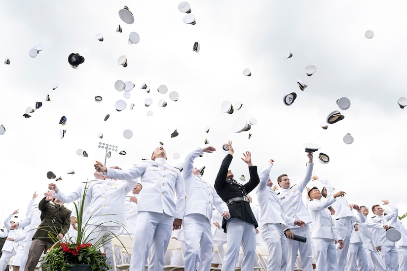 Graduates toss their caps.