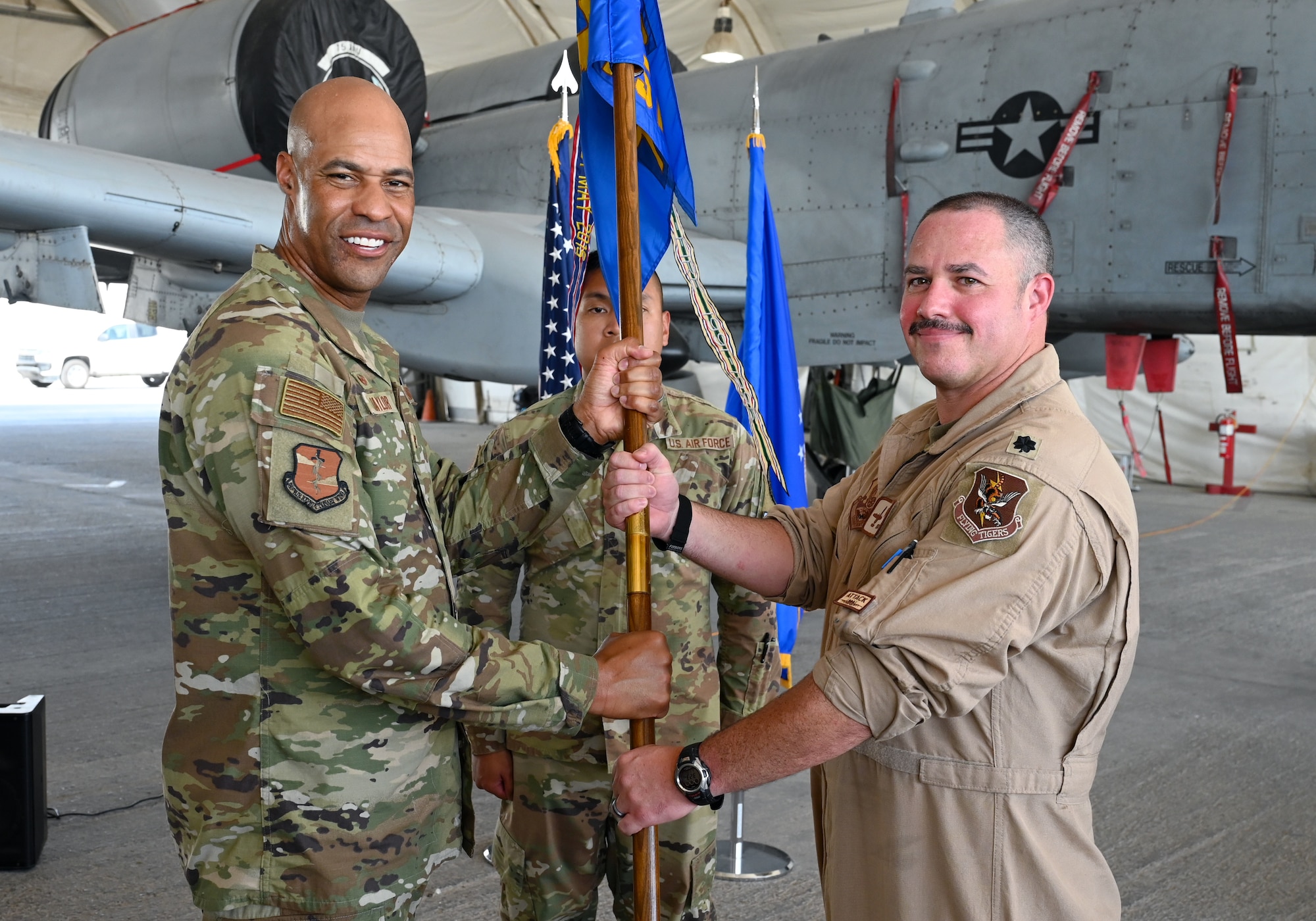A photo of two Airmen holding a guidon.