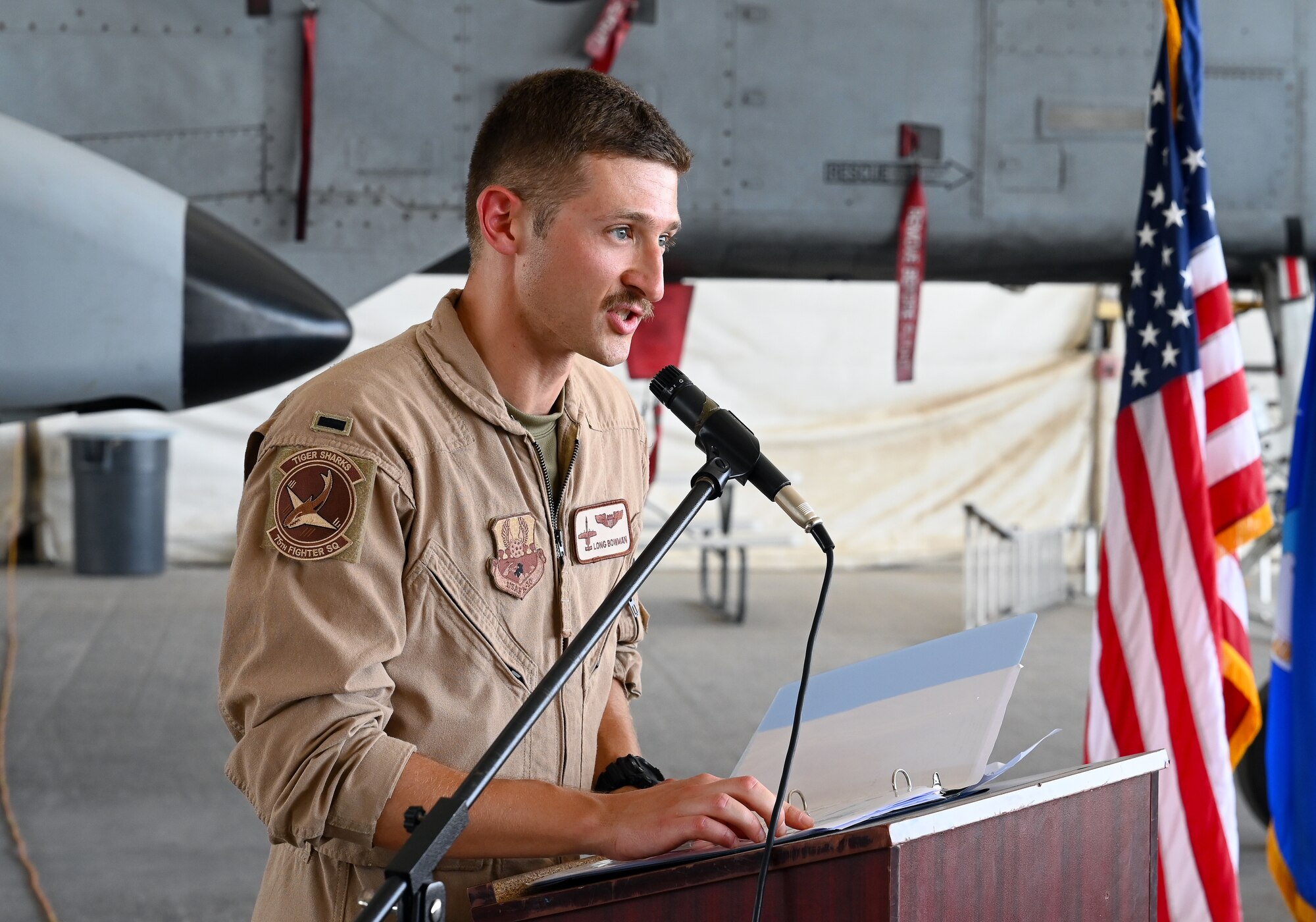 A photo of an Airman speaking at a podium.