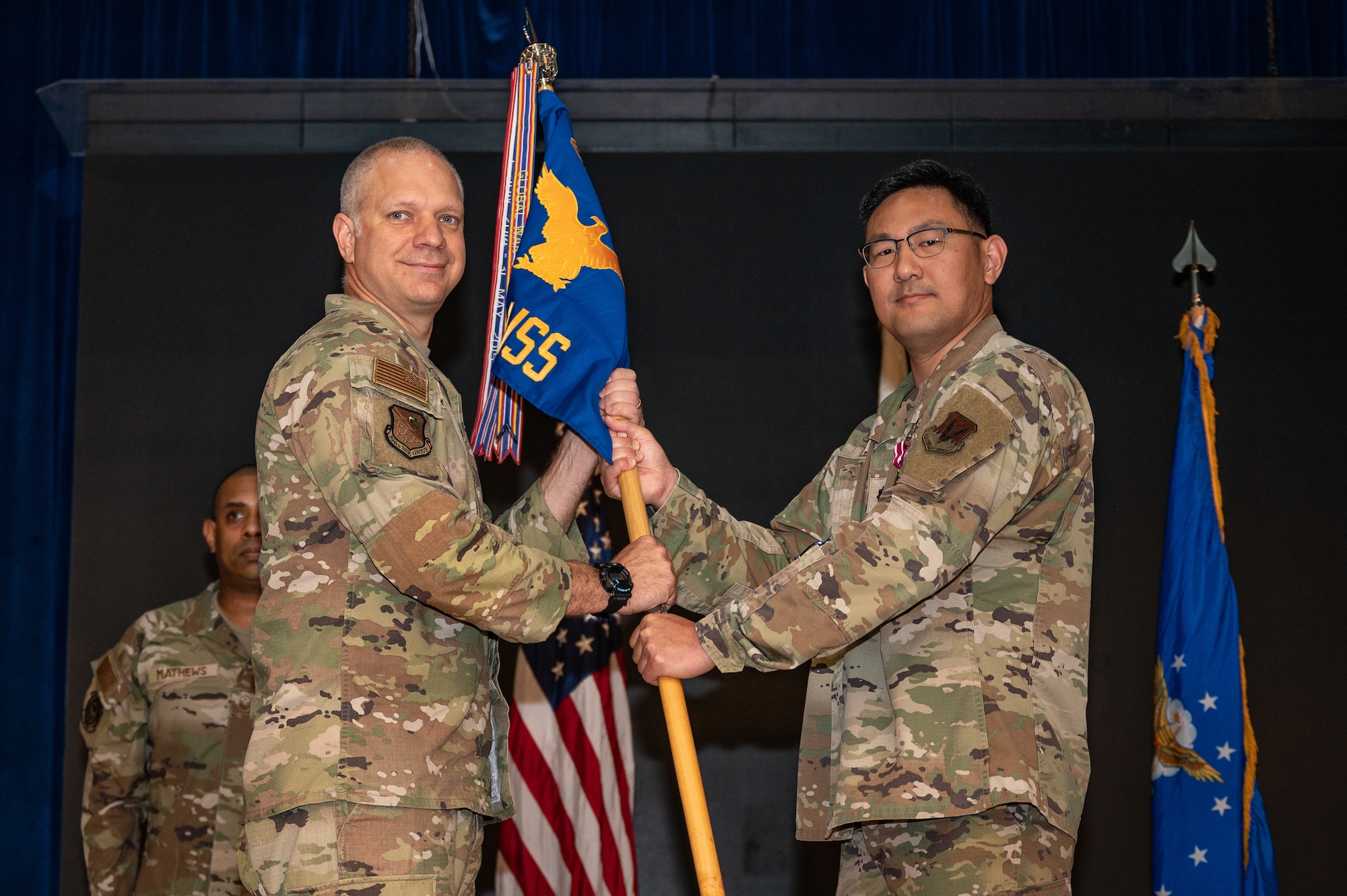 U.S. Air Force Lt. Col. Jarrod Knapp, left, 694th Intelligence, Surveillance, and Reconnaissance Group deputy commander, receives the guidon from Lt. Col. Steven Lee, 694th Intelligence Support Squadron outgoing commander, at Osan Air Base, Republic of Korea, June 15, 2023. In a change of command ceremony, the guidon symbolizes the transfer of command and the authority and responsibility associated with it. (U.S. Air Force photo by Senior Airman Thomas Sjoberg)