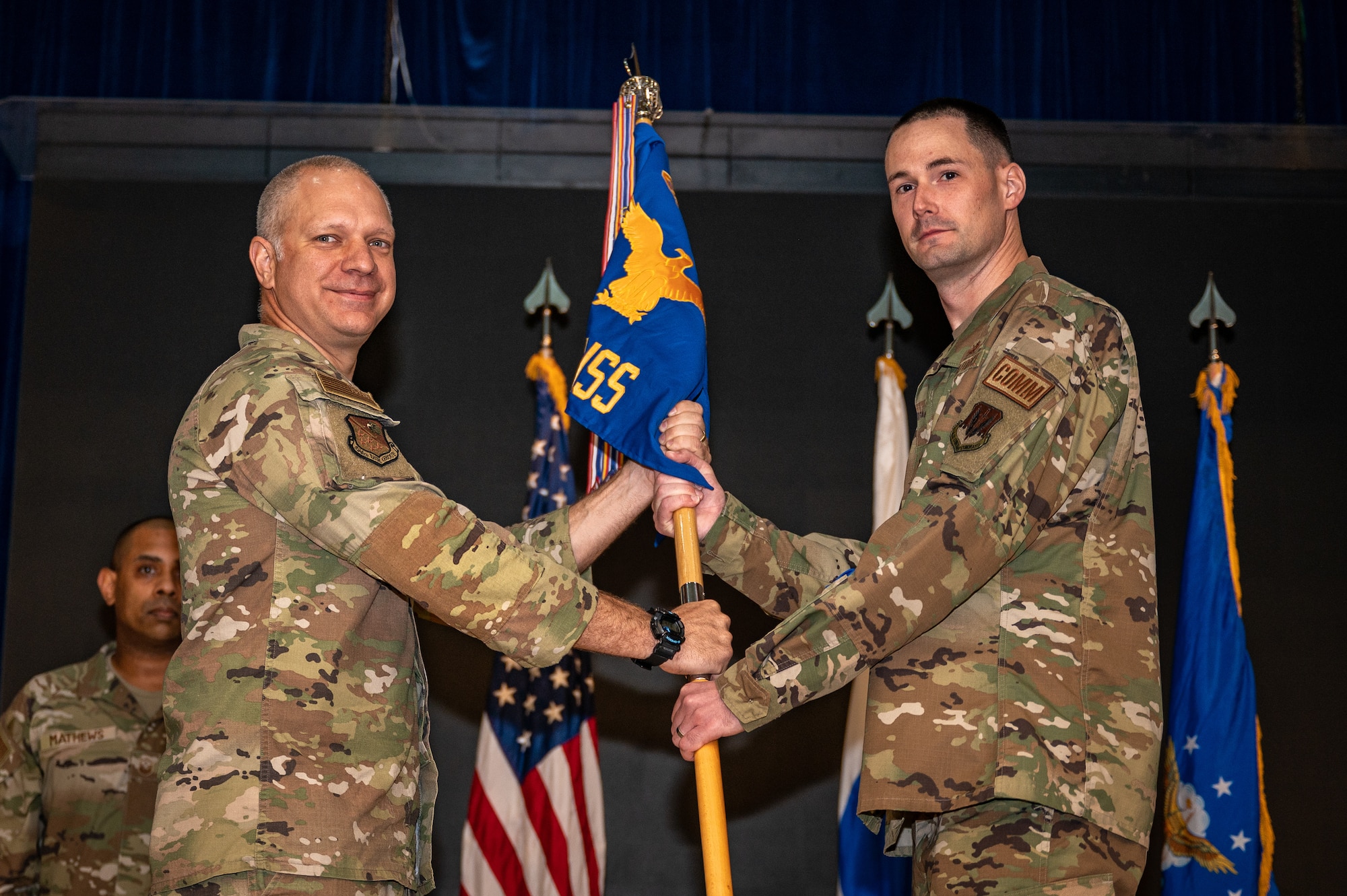 U.S. Air Force Lt. Col. Jarrod Knapp, left, 694th Intelligence, Surveillance, and Reconnaissance Group deputy commander, passes the guidon to Maj. Daniel Johnston, 694th Intelligence Support Squadron incoming commander, at Osan Air Base, Republic of Korea, June 15, 2023. Prior to taking command, Johnston was the director of operations for the 6th Communications Squadron at MacDill Air Force Base, Florida. (U.S. Air Force photo by Senior Airman Thomas Sjoberg)