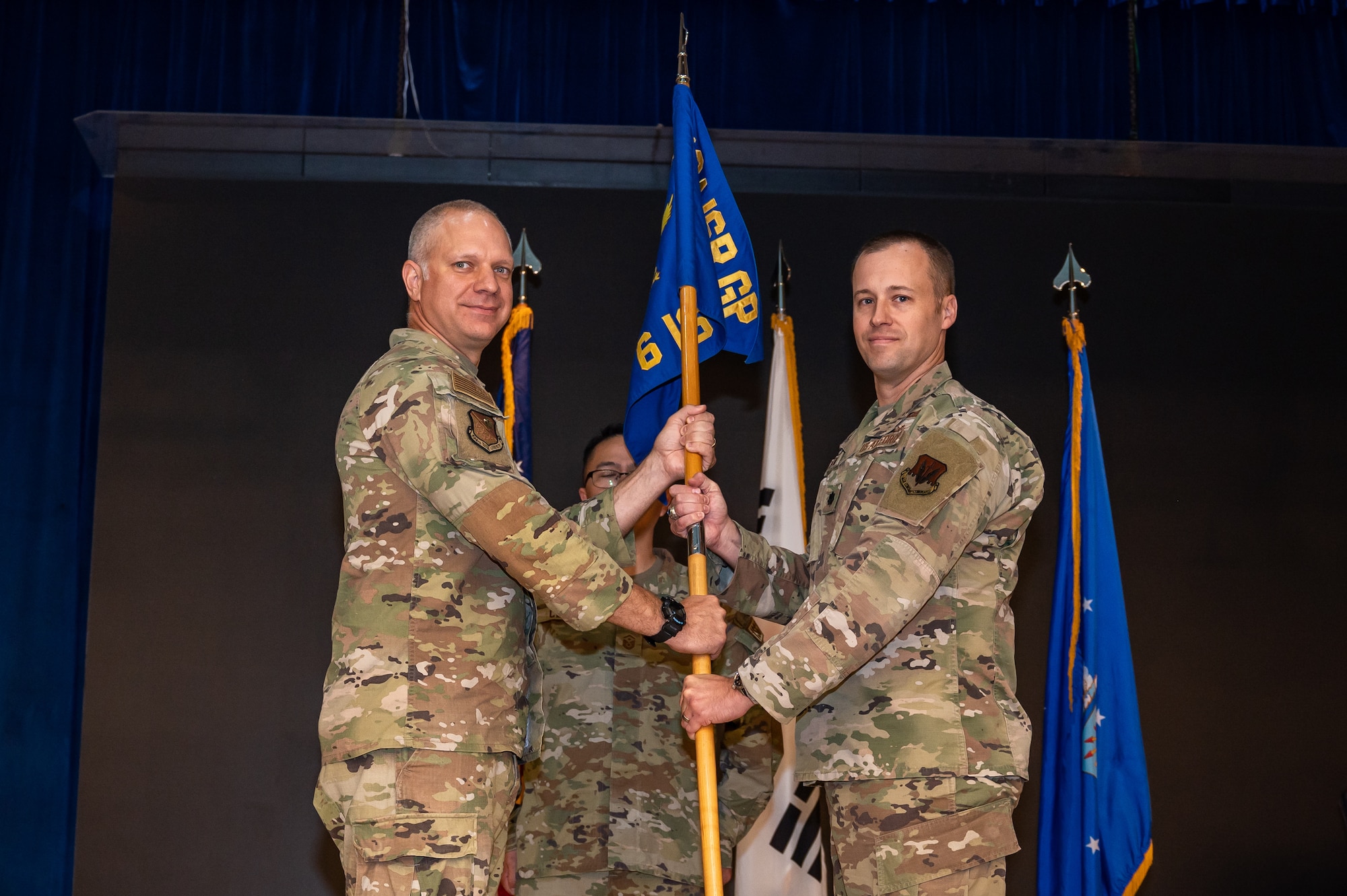 U.S. Air Force Lt. Col. Jarrod Knapp, left, 694th Intelligence, Surveillance, and Reconnaissance group deputy commander, passes the guidon to Lt. Col. Adam Fossum, 6th Intelligence Squadron incoming commander, at Osan Air Base, Republic of Korea, June 14, 2023. Prior to his current assignment, Fossum was the Director for Plans, Programs, and Analyses, Seventh Air Force, and during temporary duty service, stood up the Office of Defense Cooperation Palau. (U.S. Air Force photo by Senior Airman Thomas Sjoberg)