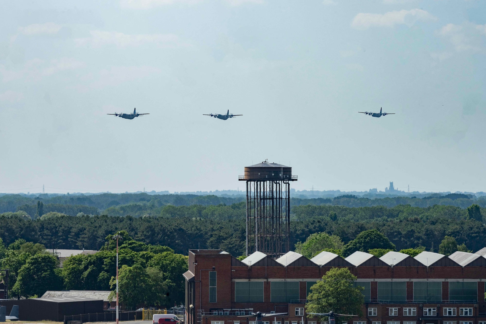 Three Royal Air Force C-130 Hercules aircraft fly over RAF Mildenhall to mark the aircraft’s retirement at RAF Mildenhall, England, June 14, 2023. The C-130 Hercules had been employed for humanitarian relief and global UK military operations since 1966.  (U.S. Air Force photo by Staff Sgt. Jesenia Landaverde)