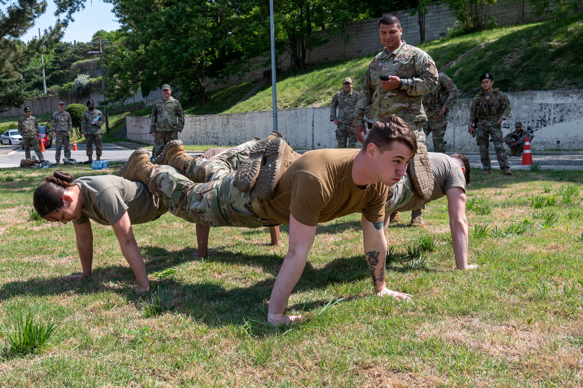 U.S. Air Force Defenders from the 51st Security Forces Squadron perform four-square push ups during the Defenders challenge as a part of Police Week 2023 on Osan Air Base, Republic of Korea, May 17, 2023. Police Week 2023 was held May 15-19 and consisted of seven events including the opening ceremony, Defender’s challenge, Excellence in competition, police expo, fallen Defender five kilometer ruck, closing ceremony and golf tournament. (U.S. Air Force photo by Airman 1st Class Aaron Edwards)