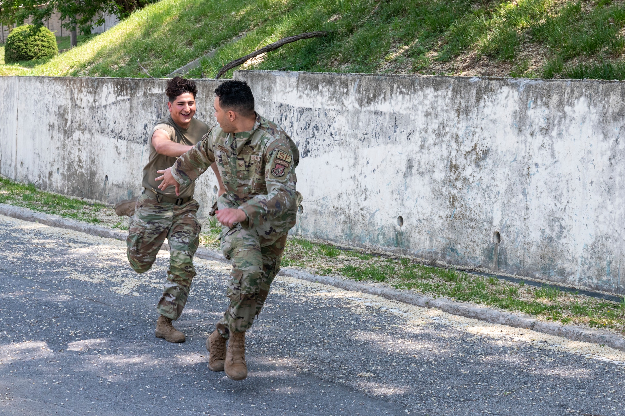 U.S. Air Force Airman 1st Class Daniel Martinez and U.S. Air Force Tech. Sgt. Joseph Robinson, 51st Security Forces Squadron Defenders, run the relay portion of the Defenders challenge as a part of Police Week 2023 on Osan Air Base, Republic of Korea, May 17, 2023. Four-person teams competed in various timed challenges related to the Defender Experience. The challenge was part of  Police Week 2023 activities.(U.S. Air Force photo by Airman 1st Class Aaron Edwards)