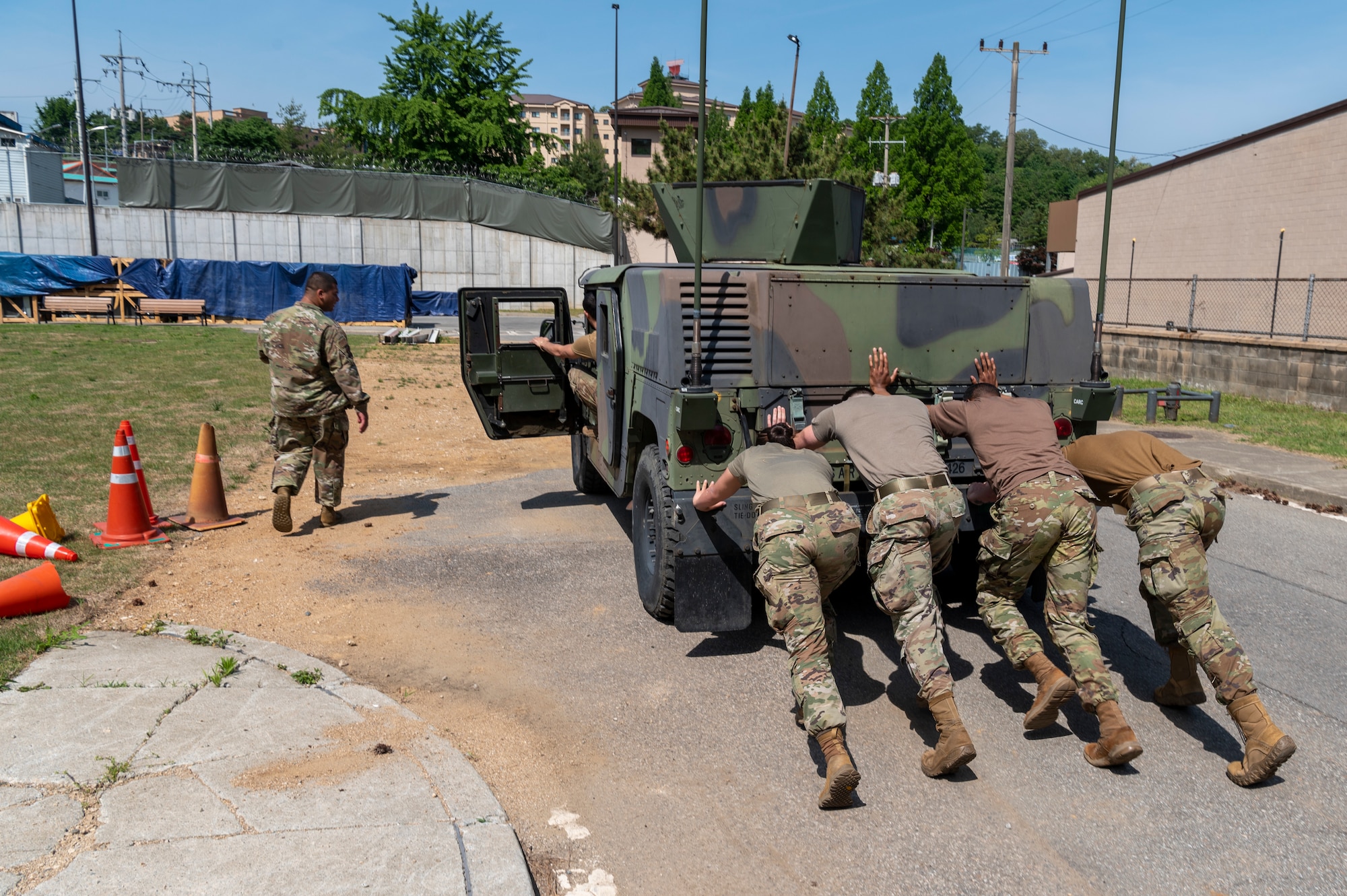 U.S. Air Force Defenders from the 51st Security Forces Squadron push a Humvee during the Defenders challenge as a part of Police Week 2023 on Osan Air Base, Republic of Korea, May 17, 2023. During the competition, Defenders performed timed challenges such as a relay race, four-square push ups, low and high crawls, fireman's carry and a humvee push. (U.S. Air Force photo by Airman 1st Class Aaron Edwards)