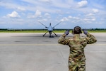 A 147th Attack Wing member marshals an MQ-9 Reaper June 13, 2023, at Ostrava Airport, Czech Republic. Exercise Air Defender 2023 integrates U.S. and allied air power to defend shared values, while leveraging and strengthening vital partnerships to deter aggression around the world.