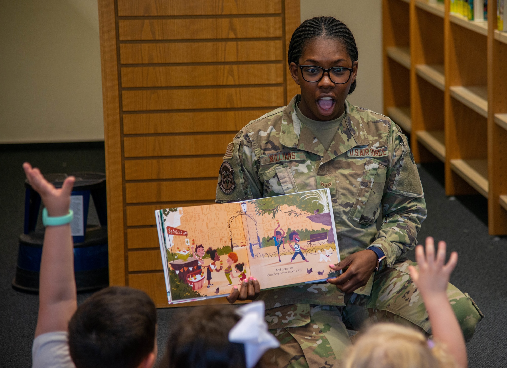 An Airman reads to children