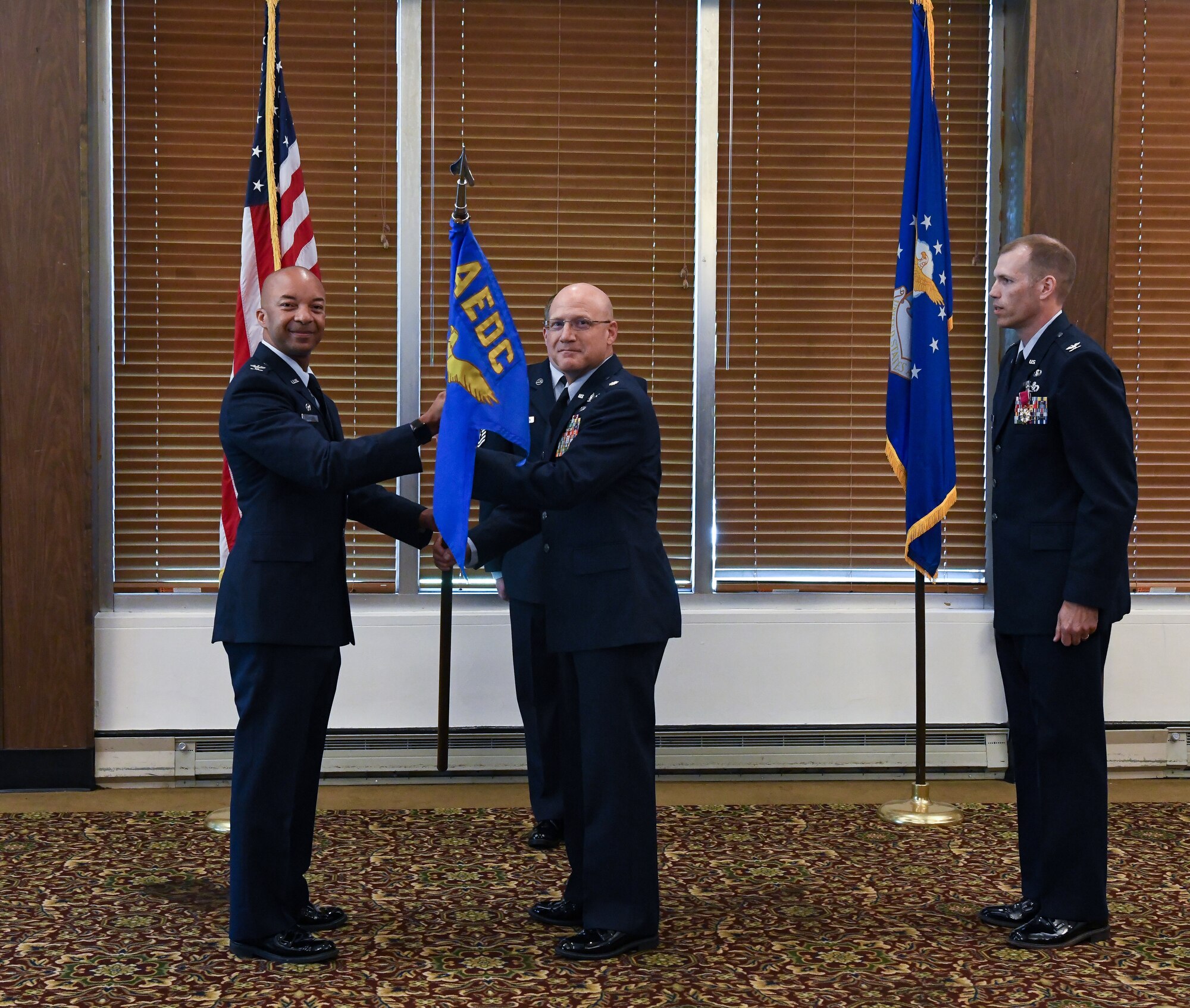 Col. Randel Gordon, left, Arnold Engineering Development Complex commander, passes the Test Support Division guidon to Lt. Col. Eric Withrow charging him with leadership of the division during a change of leadership ceremony at Arnold Air Force Base, Tenn., June 2, 2023. Also pictured is Col. R. Chris Lance, who relinquished leadership of the division during the ceremony. (U.S. Air Force photo by Jill Pickett)