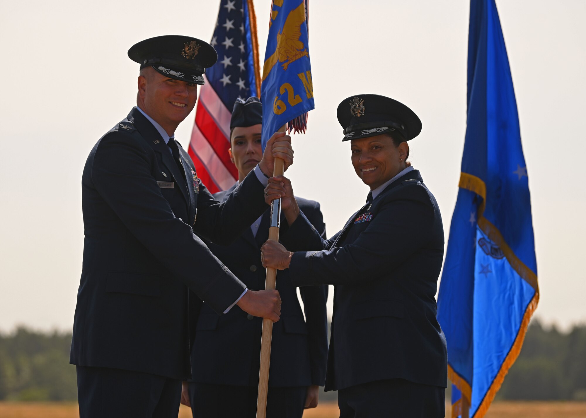 U.S. Air Force Col. David Fazenbaker, left, 62d Airlift Wing commander, presents U.S. Air Force Col. Karen Bowman, incoming 62d Medical Squadron commander, with the 62d MDS guideon at a change of command ceremony at Joint Base Lewis-McChord, Washington, June 15, 2023. The mission of the 62d MDS is to provide quality healthcare services to promote fit, resilient, ready forces, while developing and strengthening our medics to sustain future medical capabilities. (U.S. Air Force photo by Senior Airman Callie Norton)