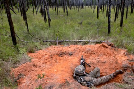 Pfc. Harley Arnold, an infantry Soldier with Company A, 1st Battalion, 114th Infantry Regiment, New Jersey Army National Guard, pulls security from her foxhole as the unit digs in positions during a rotation at the Joint Readiness Training Center at Fort Johnson, Louisiana, June 5, 2023. The rotation allowed Soldiers and units of the 44th Infantry Brigade Combat Team to build cohesiveness and readiness as they trained on large-scale combat operations.