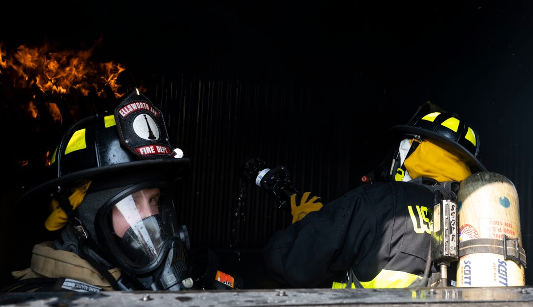 Mr. Nicholas Fontaine, 28th Civil Engineer Squadron fireman, and U.S. Army guardsman, assigned to the 109th Engineer Battalion, extinguish a fire during a structural fire exercise at Ellsworth Air Force Base, South Dakota, June 13, 2023.