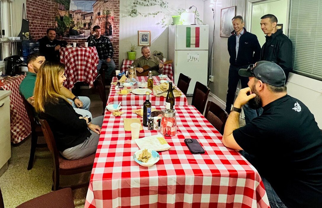 People converse in a small breakroom.